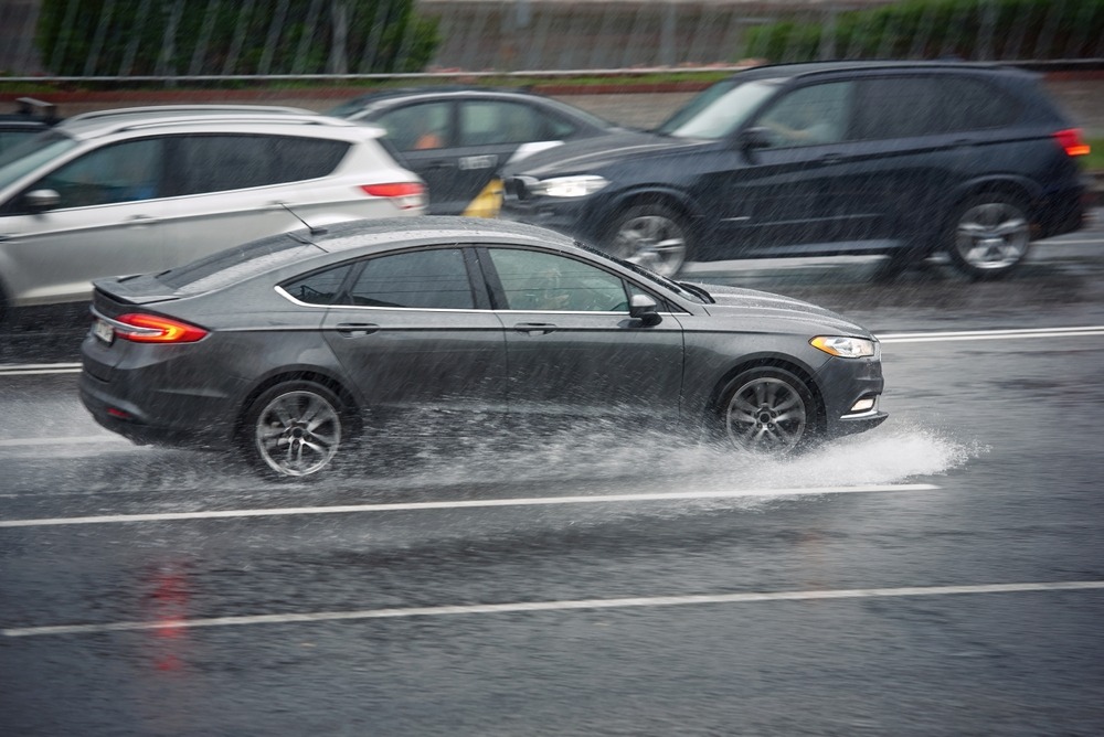 Car,Driving,Through,Puddle,At,Heavy,Rain,,Water,Splashing,Over
