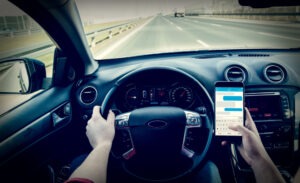 A reckless driver using a phone. Handle the aftermath of a wreck with a Fort Lauderdale reckless driving accident lawyer.