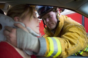 a firefighter helping an injured woman after a Miami car accident