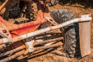 Close-up of a side-by-side vehicle with a flat tire caused by an accident.