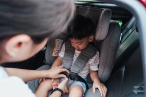 A woman buckles her three-year-old son into a car seat and wonders how compensation works in car accidents involving children.